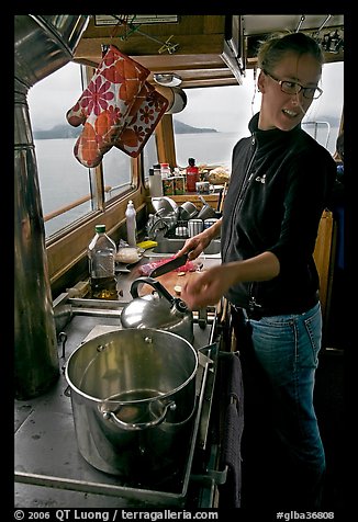 Chef cooking aboard small boat. Glacier Bay National Park (color)
