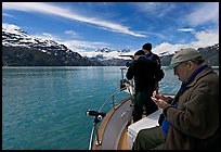 Film producer taking notes as crew films. Glacier Bay National Park, Alaska, USA. (color)