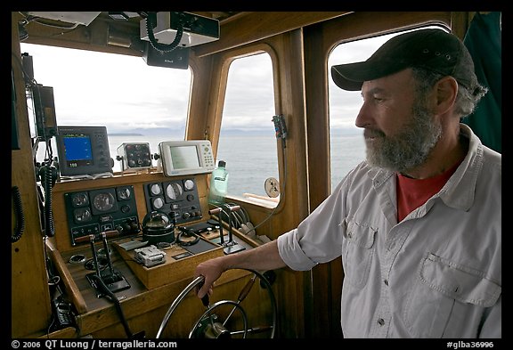 Captain steering boat with navigation instruments. Glacier Bay National Park, Alaska, USA.