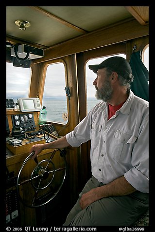 Captain steering boat using navigation instruments. Glacier Bay National Park, Alaska, USA.
