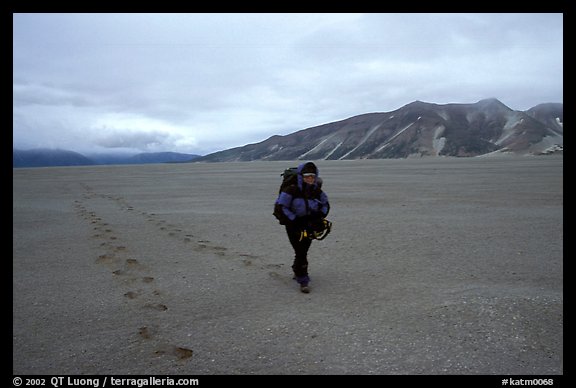 Backpacker hikes in sand-like ash, Valley of Ten Thousand smokes. Katmai National Park, Alaska