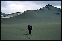 Backpacker leaves the Baked mountain behind, Valley of Ten Thousand smokes. Katmai National Park, Alaska