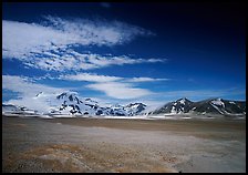 Snow-covered peaks surrounding the arid ash-covered floor of the Valley of Ten Thousand smokes. Katmai National Park, Alaska, USA.