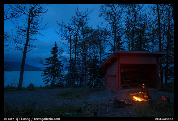 Camper sitting by campfire at night,  Brooks Camp. Katmai National Park, Alaska, USA.