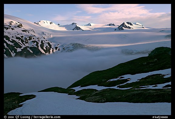 Low clouds, partly melted snow cover, and mountains. Kenai Fjords National Park, Alaska, USA.