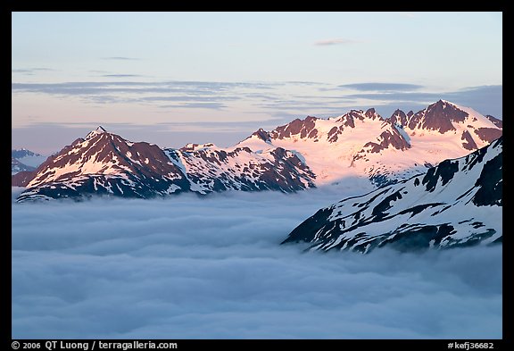 Midnight sunset on peaks above clouds. Kenai Fjords National Park, Alaska, USA.