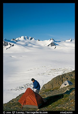 Camper exiting tent above the Harding ice field. Kenai Fjords National Park, Alaska, USA.