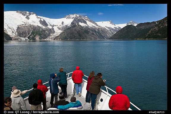 Vistors on bow of tour boat approaching glacier, Northwestern Fjord. Kenai Fjords National Park, Alaska, USA.