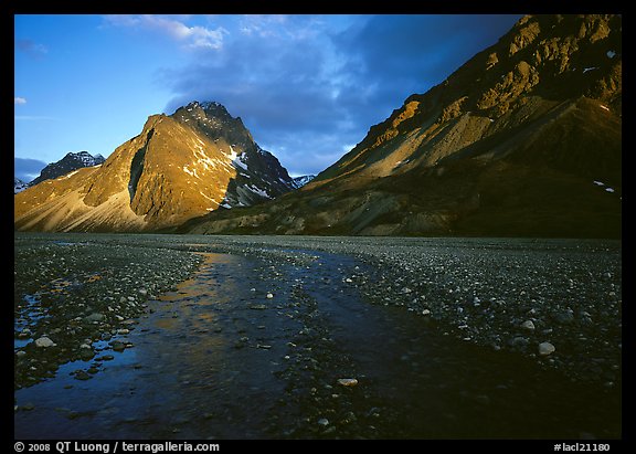 Stream on wide gravel bar and peaks at sunset. Lake Clark National Park, Alaska, USA.