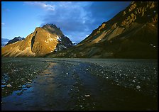 Stream on wide gravel bar and peaks at sunset. Lake Clark National Park, Alaska, USA.