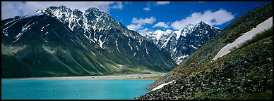 Rugged mountains rising above lake with turquoise waters. Lake Clark National Park (Panoramic color)