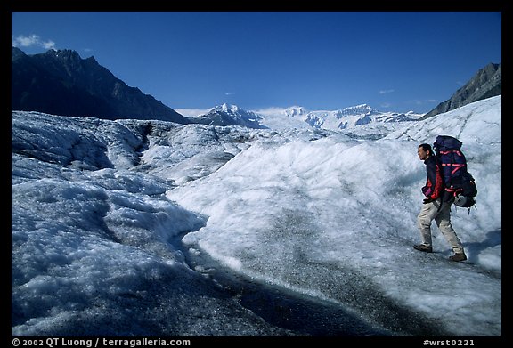 Backpacker with large pack on Root glacier. Wrangell-St Elias National Park, Alaska, USA.