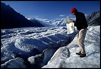 Hiker checks map on Root Glacier. Wrangell-St Elias National Park, Alaska, USA.