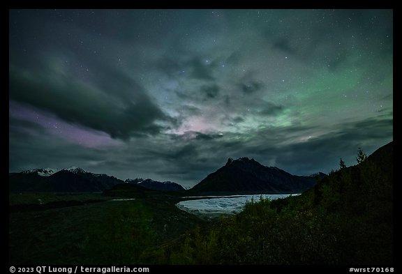 Root Glacier and Donoho Peak at night with stars, clouds, and northern lights. Wrangell-St Elias National Park, Alaska, USA.
