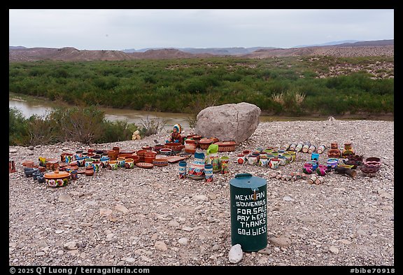 An unmanned spread of Mexican pottery is watched over only by a green honor-system can, the border landscape stretching into hazy ridges beyond.. Big Bend National Park (color)