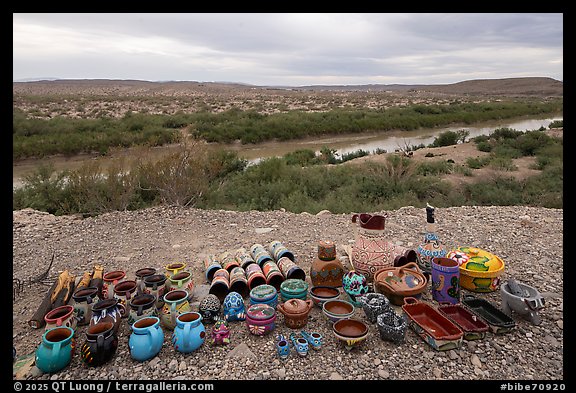 Rows of colorful ceramic mugs, bowls, and figurines line the edge of a bluff. Big Bend National Park (color)