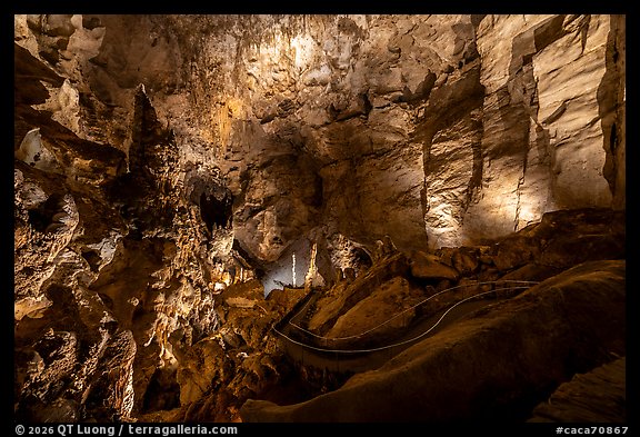 Illuminated formations and winding path threading through a towering chamber of rock. Carlsbad Caverns National Park (color)