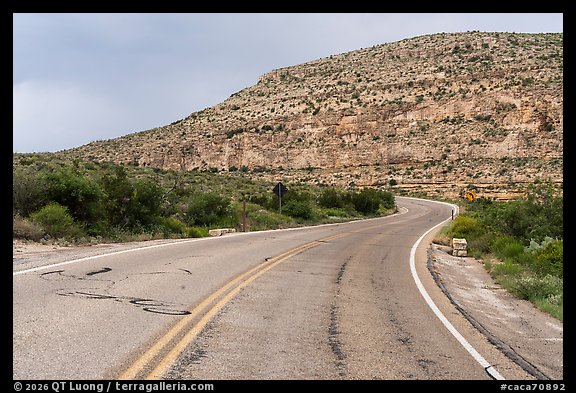 Carlsbad Caverns Highway curving toward cliffs layered with pale limestone. Carlsbad Caverns National Park (color)