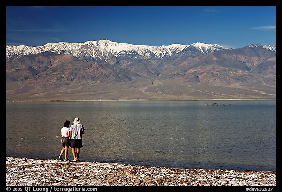 Couple watches the dragon in ephemeral lake. Death Valley National Park (color)