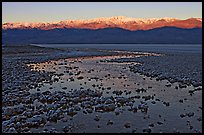 Salt pool and sunrise over the Panamints. Death Valley National Park, California, USA.
