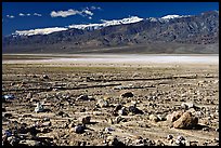 Rock field, salt flats, and Panamint Range, morning. Death Valley National Park, California, USA.