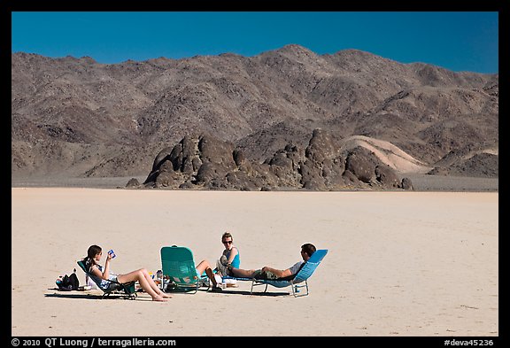 Tourists sunning themselves with beach chairs on the Racetrack. Death Valley National Park (color)
