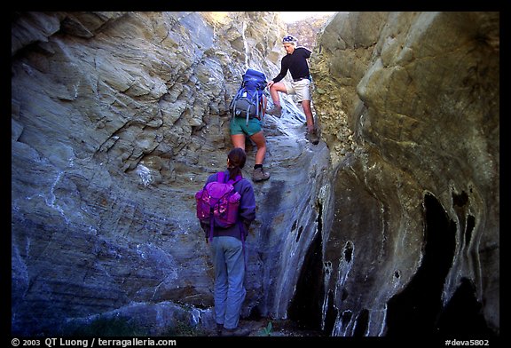Hikers climbing in a narrow side canyon. Death Valley National Park (color)