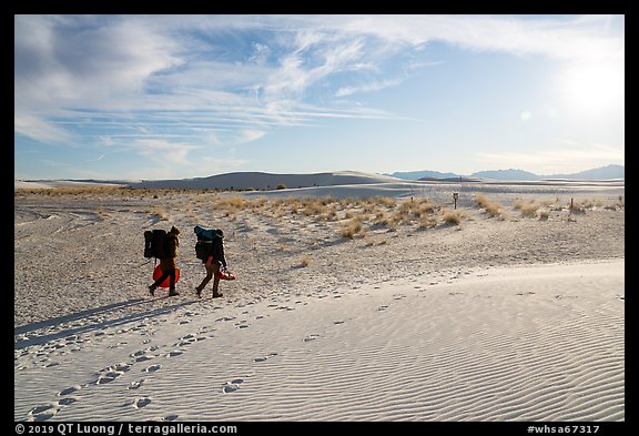 Backpackers hiking on Backcountry Trail in late afternoon. White Sands National Park, New Mexico, USA.