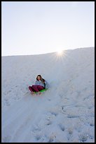 Woman sledding down dune. White Sands National Park ( color)