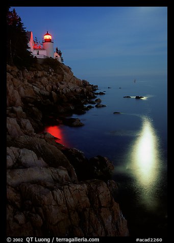 Bass Harbor lighthouse by night with reflections of moon and lighthouse light. Acadia National Park (color)