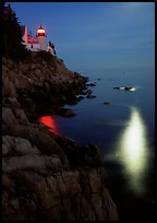 Bass Harbor lighthouse by night with reflections of moon and lighthouse light. Acadia National Park, Maine, USA. (color)