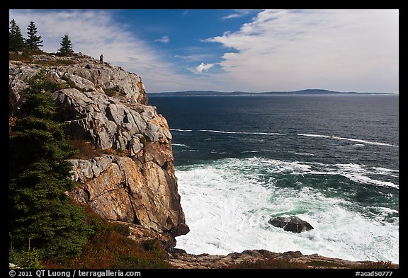 Tall granite sea cliff with person standing on top. Acadia National Park, Maine, USA.
