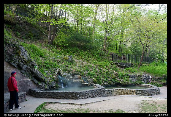 Visitor looking, hot spring cascade. Hot Springs National Park (color)