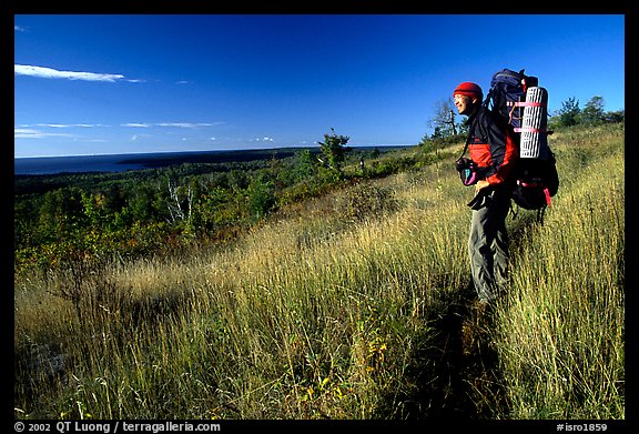 Backpacker pausing on Greenstone ridge trail. Isle Royale National Park, Michigan, USA.