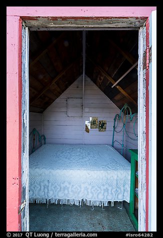 Bed framed by door of single-room Honeymoon cabin, Edisen Fishery. Isle Royale National Park (color)
