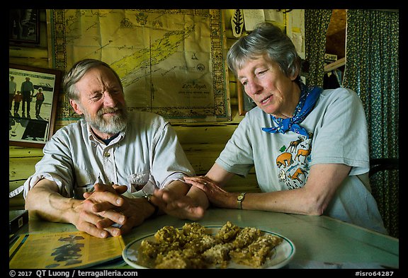 Rolf Peterson and Carolyn Peterson with plate of rhubarb pie in their home. Isle Royale National Park, Michigan, USA.