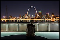St Louis skyline and Malcom Martin statue from Mississippi River Overlook at night. Gateway Arch National Park, St Louis, Missouri, USA.