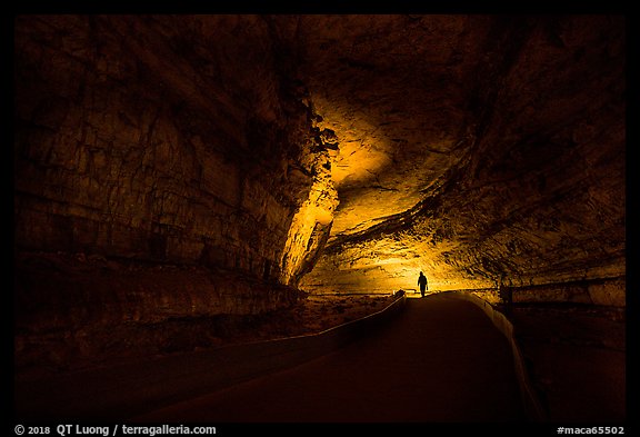 Ranger with lantern backlighted in dark cave corridor. Mammoth Cave National Park, Kentucky, USA.