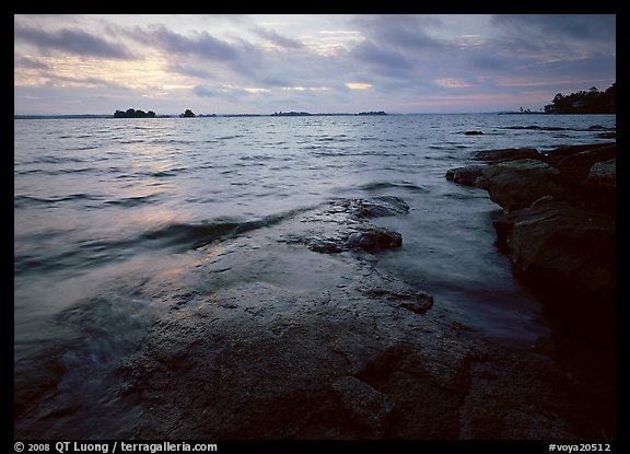 Lakeshore with eroded granite slab and clouds. Voyageurs National Park, Minnesota, USA.