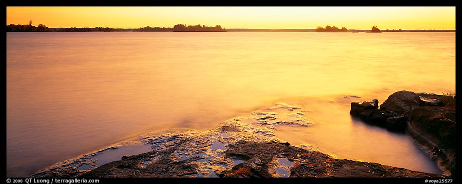 Lakeshore and glassy water painted yellow by sunrise. Voyageurs National Park (color)