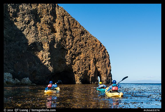 Kayakers paddling in kelp at base of sea cliff, Santa Cruz Island. Channel Islands National Park (color)