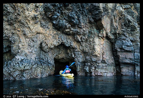 Kayaker entering narrow sea cave, Santa Cruz Island. Channel Islands National Park (color)