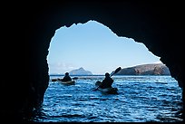 Kayakers exiting sea cave with West Anacapa in the distance, Santa Cruz Island. Channel Islands National Park ( color)