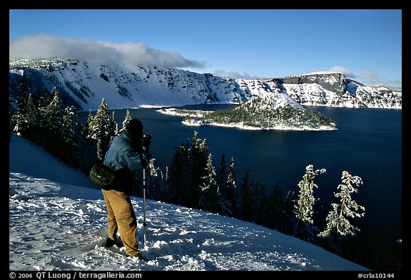Photographer on  rim of  Lake in winter. Crater Lake National Park, Oregon, USA.