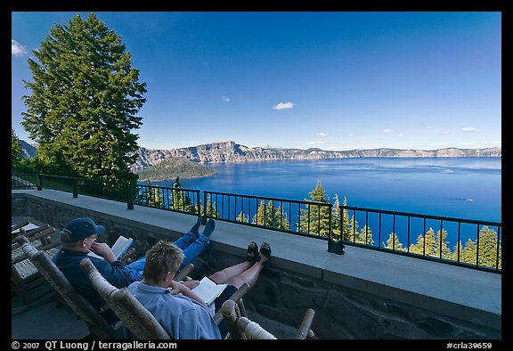 Reading on Crater Lake Lodge Terrace overlooking  Lake. Crater Lake National Park, Oregon, USA.