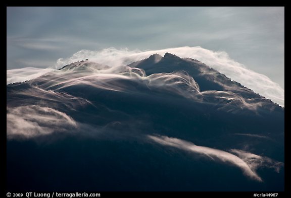 Cloudcap over backlit Mt Scott summit. Crater Lake National Park, Oregon, USA.