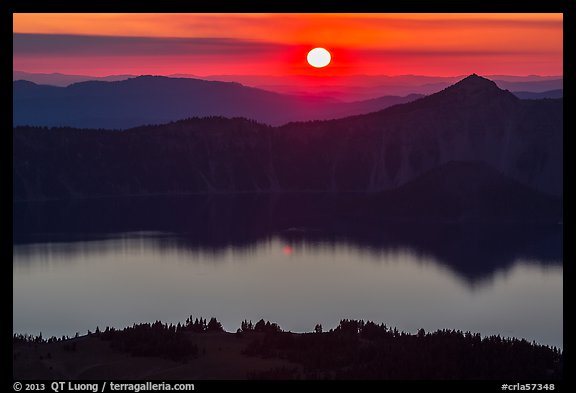 Sun setting over Crater Lake and Llao Rock. Crater Lake National Park, Oregon, USA.