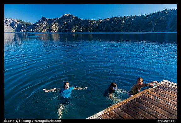 Girls swim from Wizard Island dock. Crater Lake National Park, Oregon, USA.