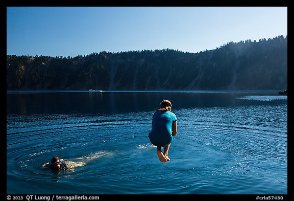 Girl jumps in water in Governors Bay, Wizard Island. Crater Lake National Park, Oregon, USA.