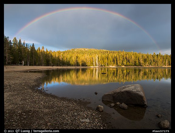 Rainbow in dark sky above Juniper Lake. Lassen Volcanic National Park, California, USA.